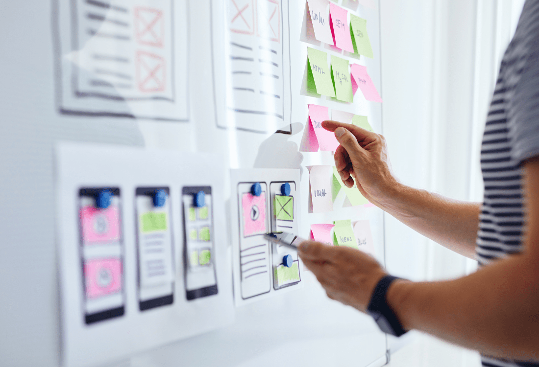 A web developer looking at ideas on a whiteboard to show the ways to make a luxury app stand out and better understand what makes a good app.